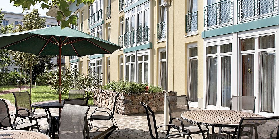Auf der Terrasse des betreuten Wohnen im Pflegeheim Eisenhuettenstadt genießt man Kaffee und Kuchen.