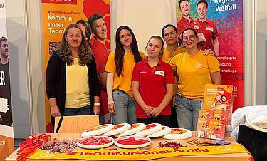 Kursana-Mitarbeitende stehen auf der Messe Frage und Antwort.